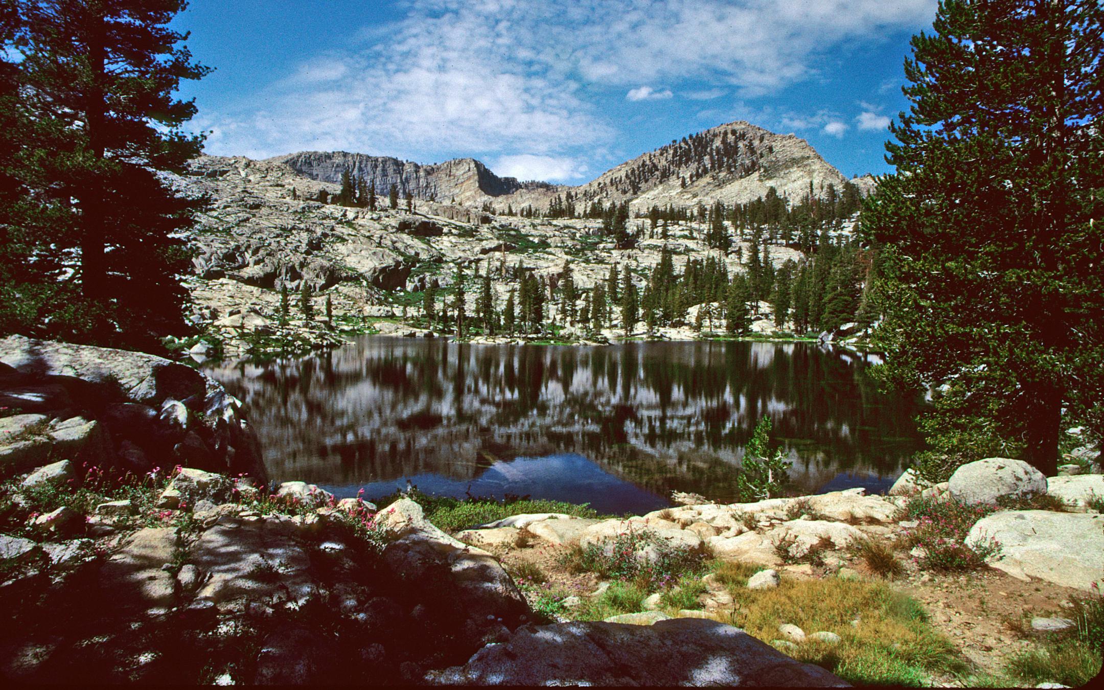 A large lake surrounded by forest covered granite walls.